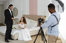 Photographer capturing moments of a married couple, during a wedding or engagement shoot.